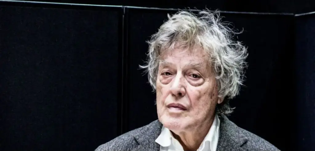 A landscape image of a white man wearing a white shirt and grey blazer