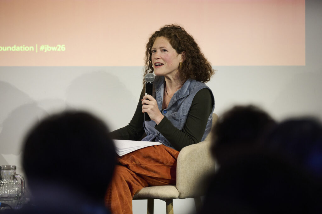 Woman talking into microphone in front of audience