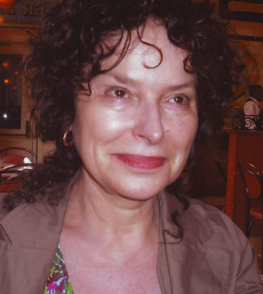 Woman with curly hair and brown jacket